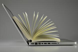 side view of laptop computer with a book on the keyboard